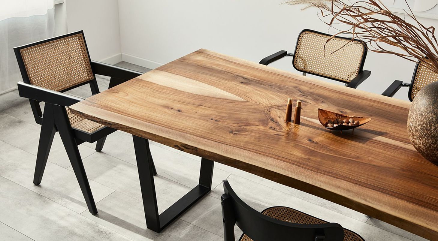 Ein Holztisch mit Korbstühlen und Dekoration